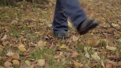 Feet-kicking-autumn-leaves-in-rural-scene