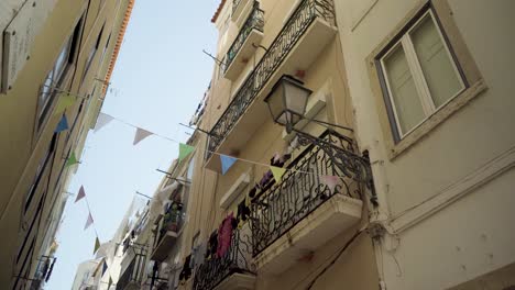 Lisbon-old-street-with-balcony-and-ancient-street-lamp-at-sunshine