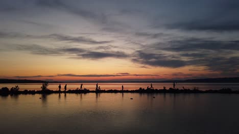 People-walking-around-a-fishing-place-at-lake-Balaton-in-the-sunset