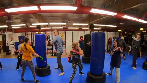 Adult-students-practicing-strikes-and-punches-while-participating-in-a-self-defense-class-at-martial-arts-school