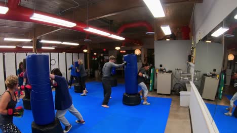 Adult-students-practicing-rapid-strikes-and-punches-while-participating-in-a-self-defense-class-at-martial-arts-school