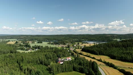 Slow-panning-aerial-view-of-the-countryside-with-mountains-and-lake-in-the-background