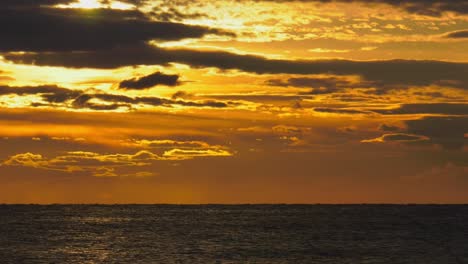 Dark-ocean-waves-under-orange-dawn-skies,-mediterranean-seascape