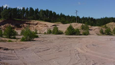 Moving-through-old-sandy-quarry-with-powerlines-in-front
