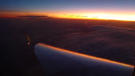 Airplane-turning-left-over-river-and-clouds,-amazing-sunset-view