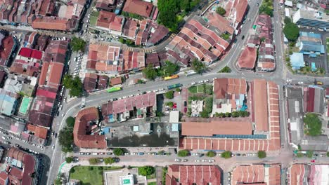 Aerial-view-of-Kampung-Kolam-avenue-with-homes-and-buildings-along-the-route,-Aerial-drone-tilt-reveal-shot