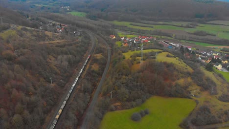 drone-flight-over-a-freight-train-transporting-cargo-through-countryside