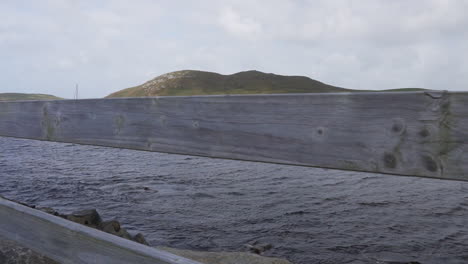 Die-Zeitlupe-Zeigt-Eine-Aufnahme-Von-Booten,-Die-An-Einem-Windigen-Tag-Im-Atlantik-Ankerten,-Und-Einer-Insel-Im-Hintergrund-In-Irland-In-4K