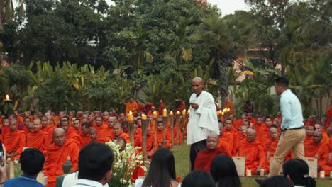 Exterior-Medium-Slow-Motion-Shot-of-Monks-Sitting-Down-For-Ceremony-in-Evening-Time