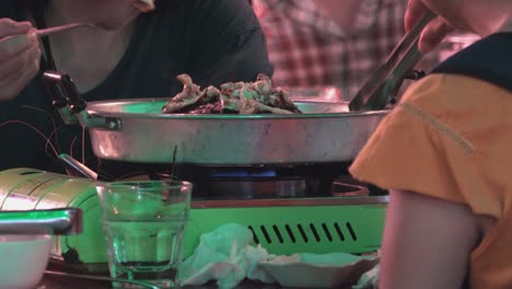 Slow-Zoom-Shot-of-a-Couple-Eating-Asian-BBQ-Outdoors-at-Night