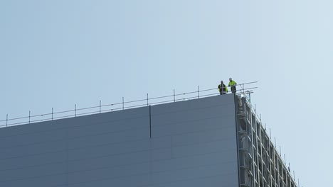 Static-shot-of-construction-workers,-working-at-height-on-a-power-station-construction-site