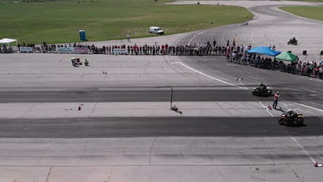 Overhead-view-of-two-motorcycles-accelerating-off-drag-race-start-line