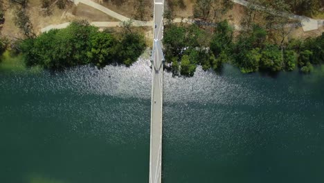 Vertical-drone-footage-looking-down-on-small-walking-bridge
