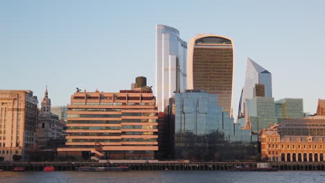 View-of-Fenchurch-building-and-Sky-Garden-with-corporate-offices,-panning-up-from-water