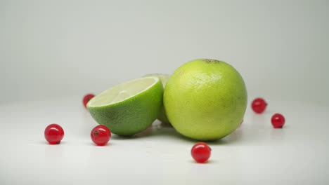 Fresh-Green-Lime,-One-Sliced-Horizontally-With-Red-Currants---Close-Up-Shot