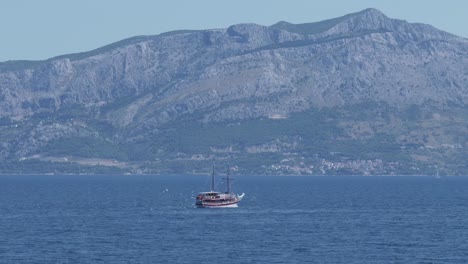 A-squabble-of-seagulls-following-a-sailboat-off-the-coast-of-Postira,-Brac-island,-Croatia