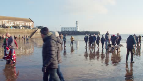 Winter-sea-swimmers-dressed-in-fancy-dress-and-spectators-gather-on-the-beach-in-Scarborough-UK-for-new-years-day-annual-sea-swim