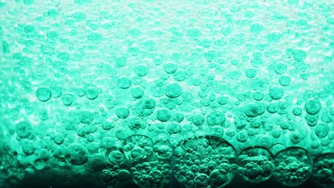Makroaufnahme-Vieler-Blauer-Blasen,-Die-Sich-Auf-Dunklem-Grund-Im-Wasser-Bilden