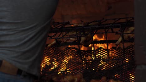 Man-Removes-Chicken-From-Large-Rotisserie-Grill