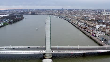 Jacques-Chaban-Delmas-Bridge-in-Bordeaux-France-with-car-traffic-and-Garonne-river-below,-Aerial-dolly-left