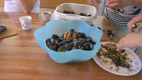 Fresh-seashells-in-blue-bowl-on-wooden-table