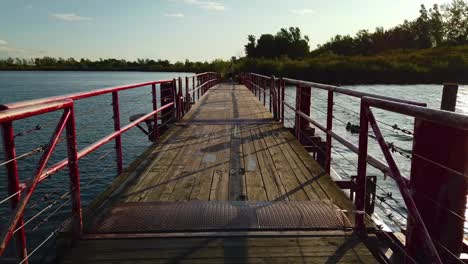 Ein-Jogger,-Der-über-Eine-Rote-Schwimmende-Holzbrücke-Läuft