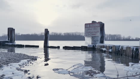 Low-angle-view-lakeside,-no-fishing-prohibition-sign,-Winter-landscape
