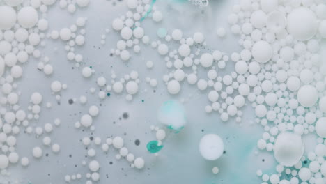 Weiße-Blasen,-Die-Sich-In-Einer-Transparenten-öligen-Flüssigkeit-Bewegen-Und-Platzen