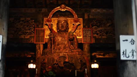 Hand-held-shot-of-a-buddhist-stature-iluminated-by-warm-candle-light-in-Kencho-ji,-Kamakura,-near-Tokyo