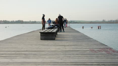 People-on-the-pier-undress,-prepare-to-take-a-bath-in-cold-water