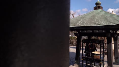 Coming-from-behind-a-column-and-seeing-the-beautiful-temple-structures-of-the-Hasedera-shrine-in-Kamakura,-Japan---wide-shot