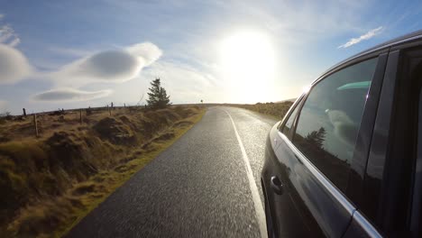 Driving-on-a-mountain-road-in-Wicklow,-Ireland,-on-a-sunny-day