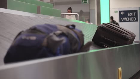 Hand-taking-luggage-from-conveyor-belt-at-airport,-baggage-claim-concept