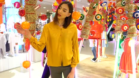 Asian-woman-with-a-beautiful-smile-in-a-department-store-looking-at-home-decorations-in-a-Chinese-style