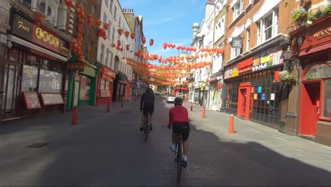 Radfahrer-Fahren-Während-Der-Sperrung-In-London-Unter-Dem-Chinatown-Gate-Hindurch