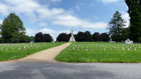 Gettysburg-National-Cemetery,-site-of-Civil-War-military-veterans,-American-flags-blow-in-wind-on-summer-day