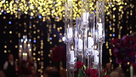 Beautiful-crystal-candlestick-with-candles-on-a-shiny-colorful-bokeh-background-flickering,-copy-space