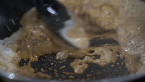 Mixing-Dark-Massaman-Curry-Paste-with-Fresh-Coconut-Milk-in-Non-Stick-Pan---Close-Up