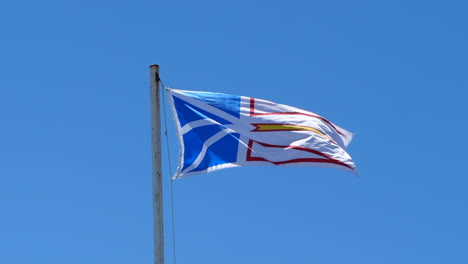 Flag-of-Newfoundland-and-Labrador-flying-against-blue-sky