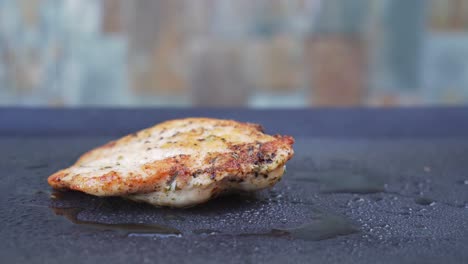 Tasty-grilled-chicken-meat-on-grill-pan-with-smoke-in-background,-side-closeup