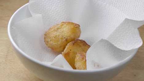Sunday-Lunch---Roast-Potatoes-Being-Added-to-a-Bowl-Lined-with-Kitchen-Paper-to-Drain
