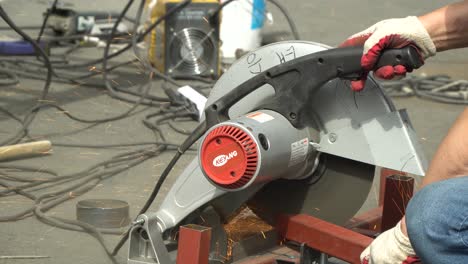 Worker-Cutting-A-Metal-Tubular-With-Cut-off-Machine---close-up