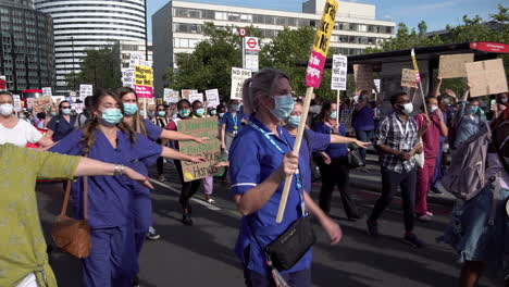 Demonstranten-Des-National-Health-Service-Pay-Justice-March-üben-Soziale-Distanzierung,-Indem-Sie-Ihre-Arme-Ausstrecken