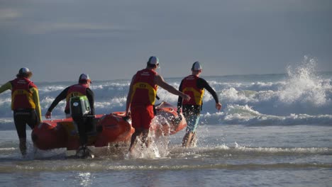 Freiwillige-Lebensretter-Tragen-Ein-Aufblasbares-Schlauchboot-Im-Meer-–-Rettungsschwimmer-Im-Dienst-Und-Bereiten-Sich-Auf-Die-Patrouille-Vor-–-Currumbin,-Gold-Coast,-Queensland,-Australien