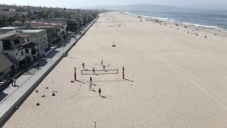 Vista-Aérea-De-Amigos-Jugando-Voleibol-En-Golden-Sands-Hermosa-Beach,-California