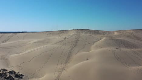 Dune-du-Pilat-Sandhill-in-France-with-People-walking-along-the-top-with-footprints-marked-in-the-sand,-Aerial-flyover-shot
