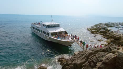 Tourists-entering-on-a-Tour-Boat,-Tourist-Sightseeing-Boat,-to-sailing-across-the-Cinque-Terre-sea,-Italy-coast