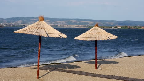 Two-reed-umbrellas-on-the-bank-of-the-river-beach