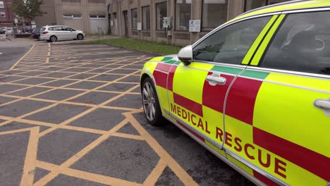 UK-NHS-emergency-rapid-response-medical-rescue-service-car-outside-hospital-pan-right