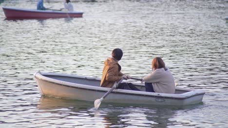 Two-Romantic-Japanese-Couple-Rowing-On-A-Rowboat-in-The-Lake-In-Tokyo,-Japan---Wide-Shot